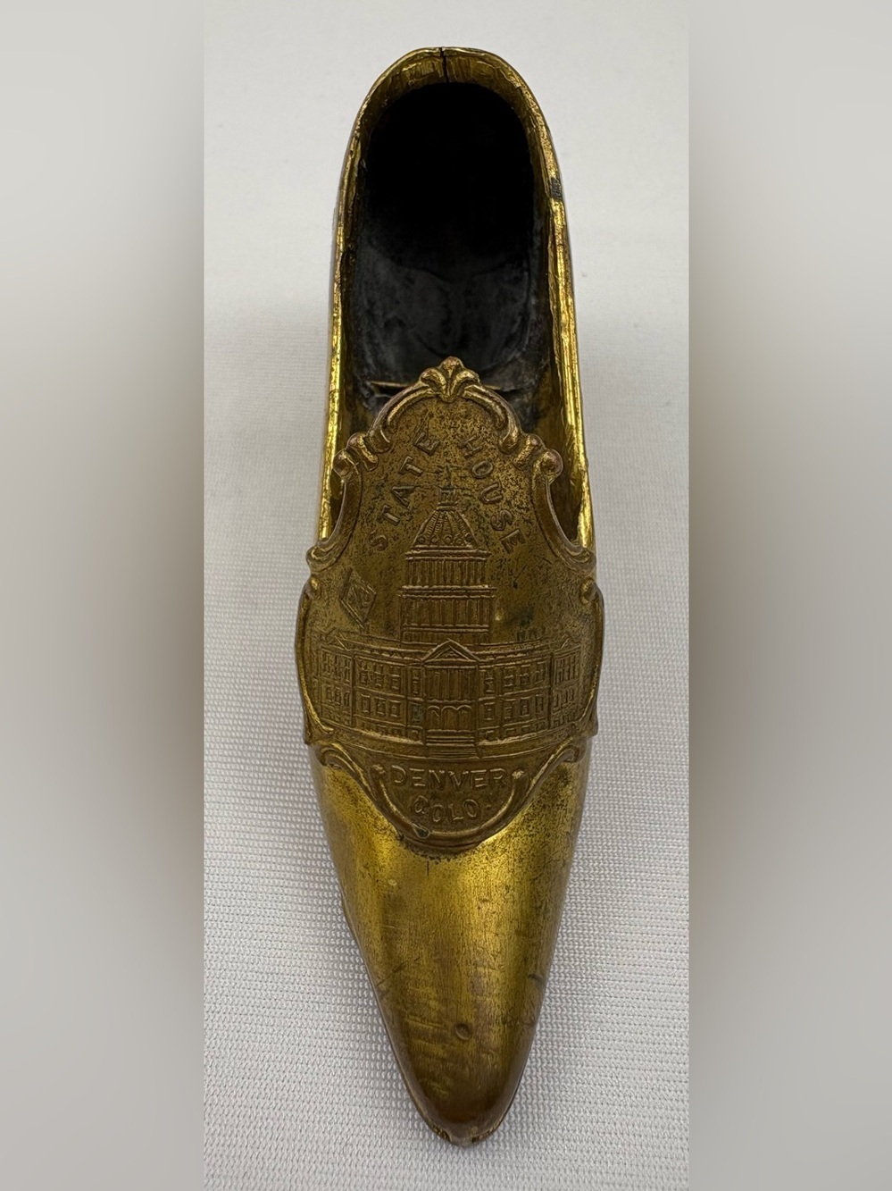 Antique Victorian-style metal pin cushion souvenir shaped like high-heeled shoe